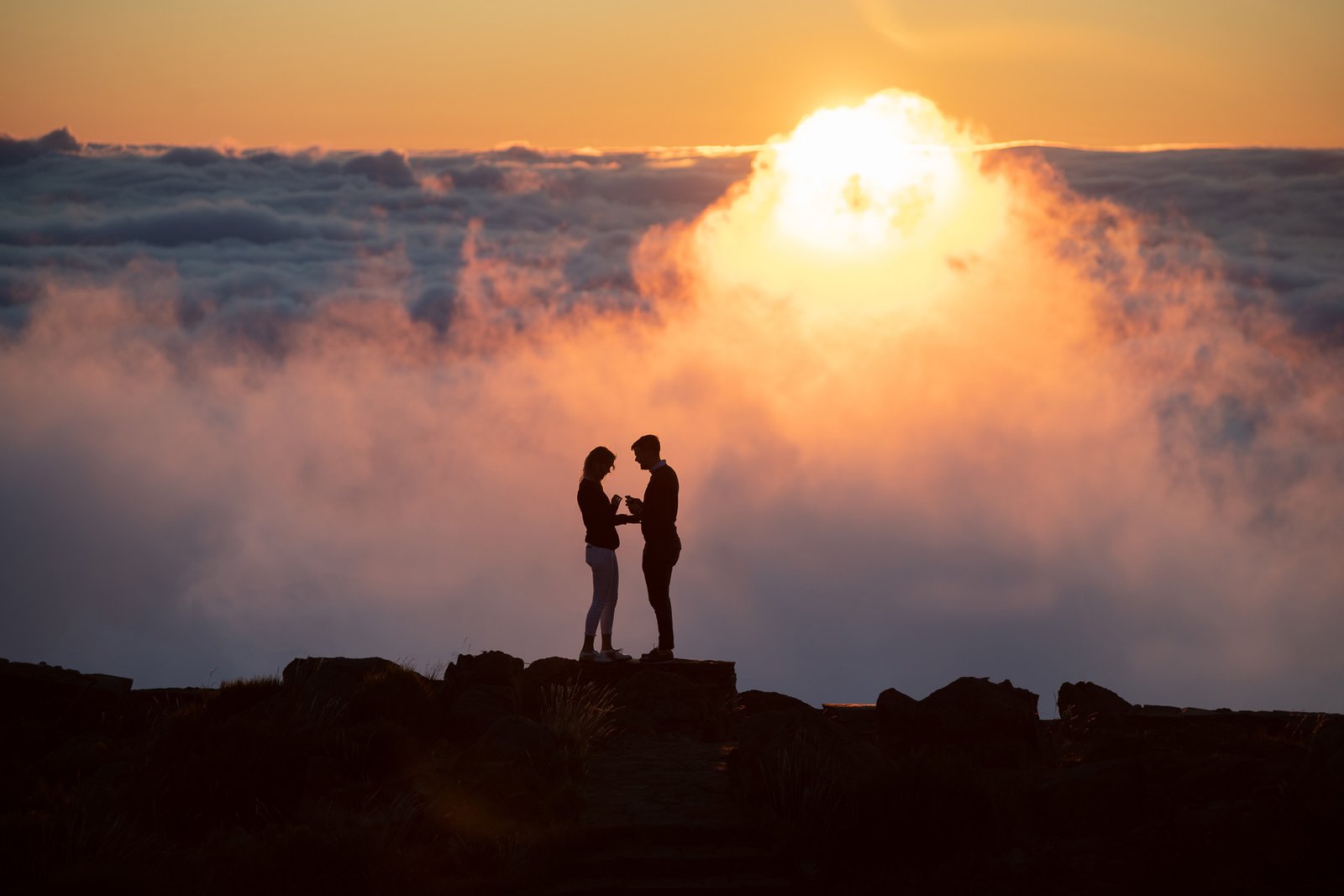he put a proposal ring to her finger in front of the sun, above the clouds, Arieiro Peak, Madeira