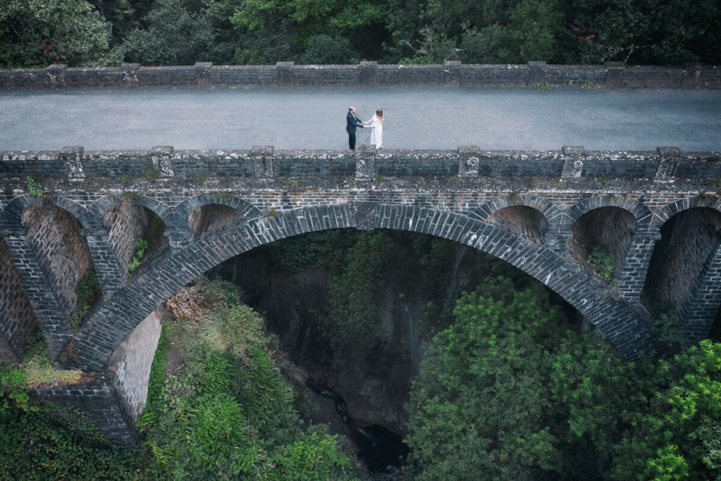 Just-married couple on old bridge