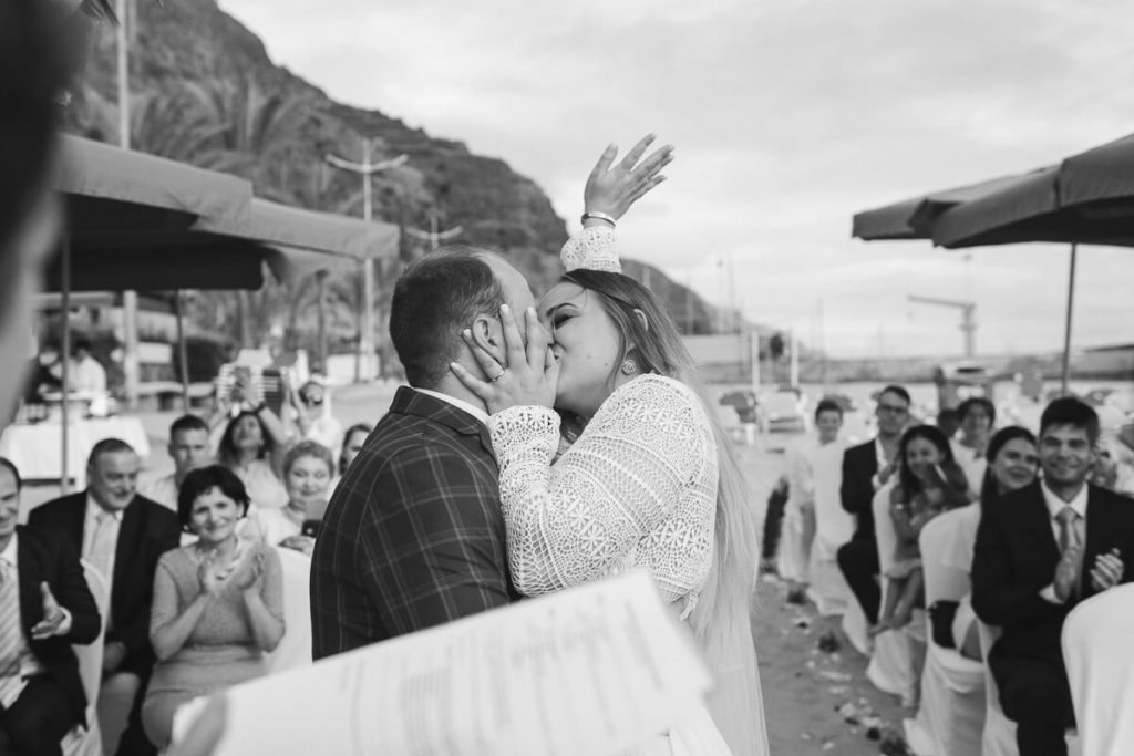 bride and groom kissing on the beach