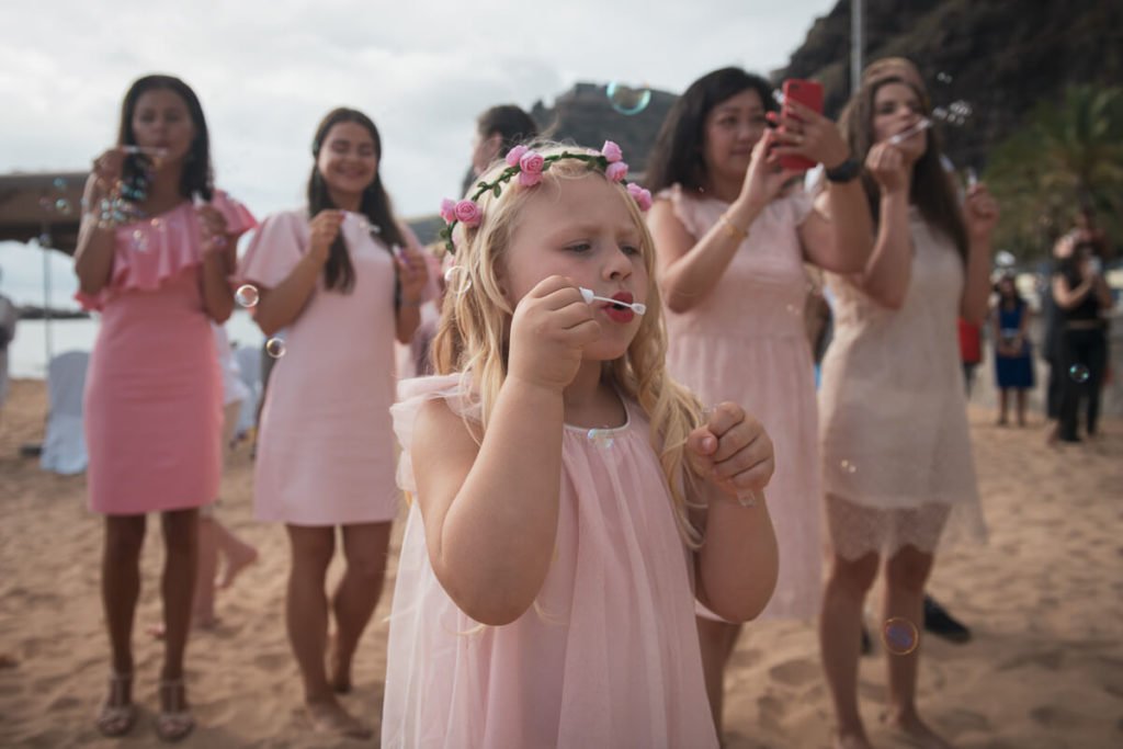 kids blowing bubbles at beach wedding ceremony
