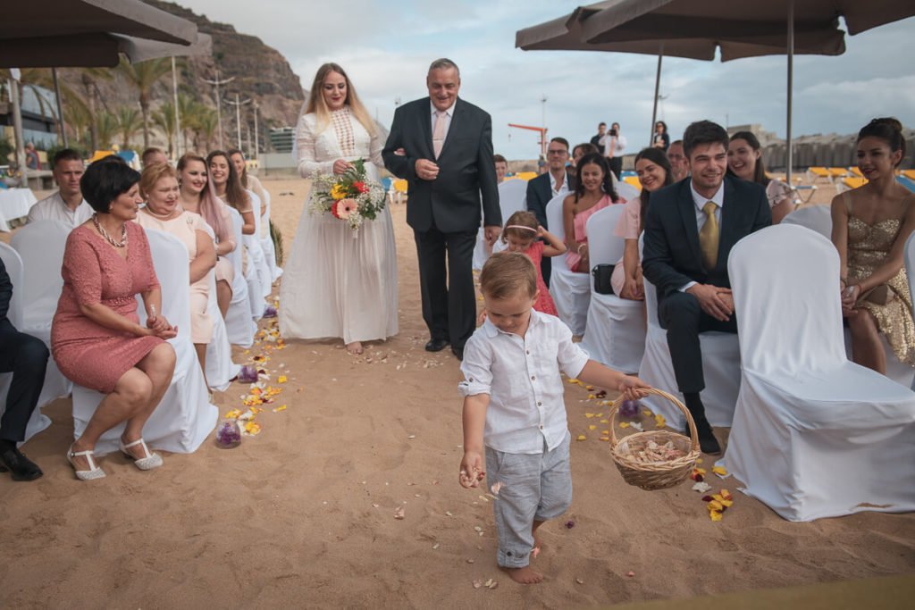 father takes a bride to wedding ceremony at the beach
